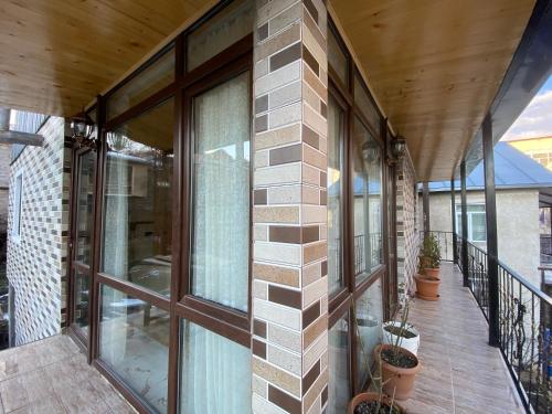a balcony of a building with glass windows at Guest House Sunrise in Khulo