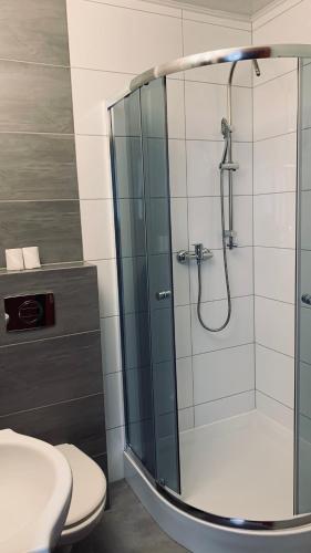 a bathroom with a shower with a toilet and a sink at Bianco - pokoje noclegowe in Częstochowa