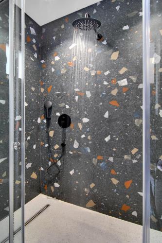 a bathroom with a shower with a rock wall at Charisma Boutique Hotel in Parga