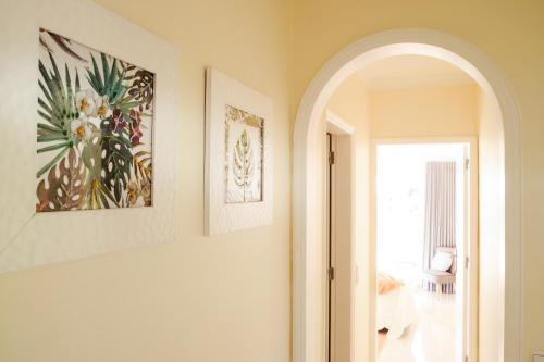 un couloir avec une arche et une peinture sur le mur dans l'établissement Palmeira Galé Apartment, à Albufeira