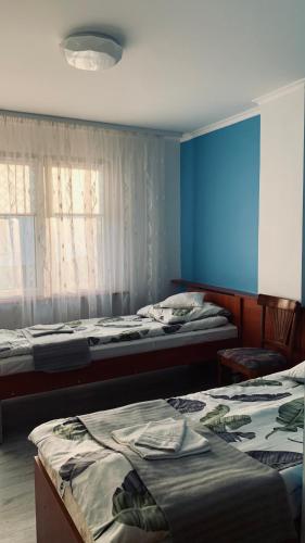 a bedroom with two beds and a blue wall at Bianco - pokoje noclegowe in Częstochowa