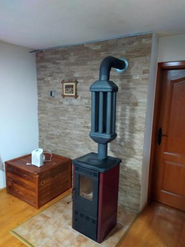 a wood stove in a room with a wall at VILA PLANINSKI SAN in Sekulić 