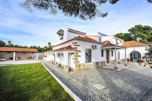 a large white house with a yard at Santo António's Guesthouse in Cascais