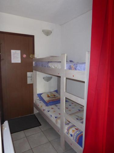 two bunk beds in a small room with a door at à la montagne en famille App106 in Cauterets