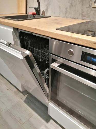 a kitchen with an open dishwasher and a sink at Rynek Nowa Ruda in Nowa Ruda