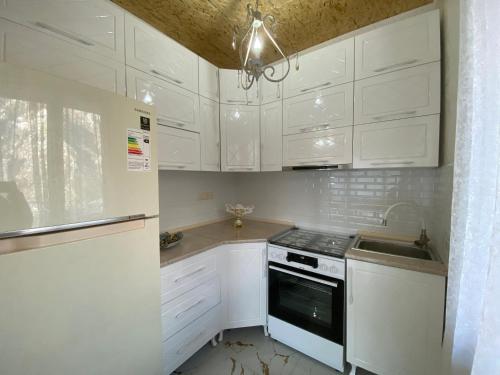 a white kitchen with white cabinets and a sink at Guest House Sunrise in Khulo