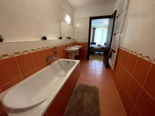 a bathroom with a tub and a toilet and a sink at Apartment 122 Čertovka in Karlovy Vary
