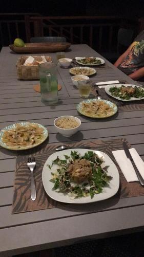 a wooden table with plates of food on it at Fafapiti Lodge Fakarava in Fakarava