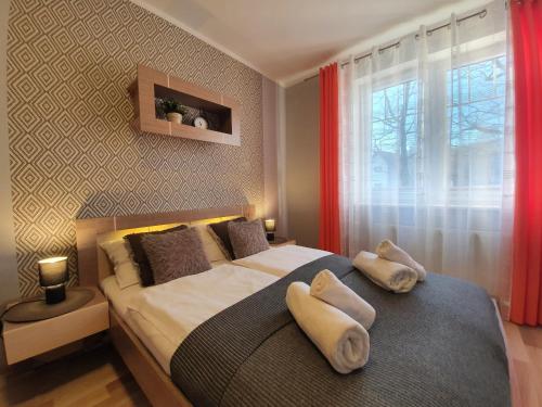 カルパチにあるApartamenty Rezydencja Pod Dębami Sun&Fun - blisko centrumのベッドルーム1室(大型ベッド1台、タオル2枚付)