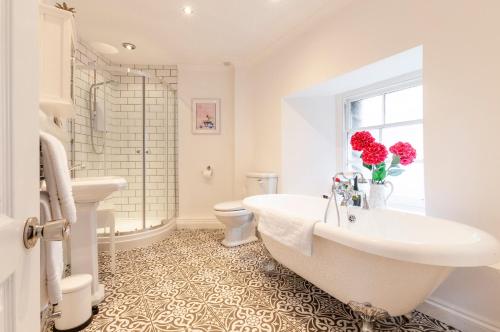 a bathroom with a tub and a toilet and a sink at The Mews, Millfields, Plymouth Centre by Pure B in Plymouth