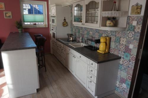 a kitchen with white cabinets and black counter tops at Altstadt-Insel in Rathenow