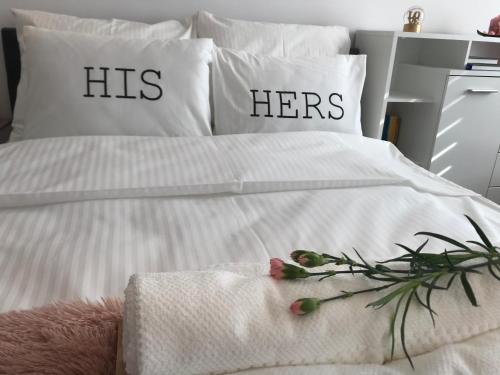 a bed with his and hers pillows on it at Apartament Romantyczny in Sandomierz