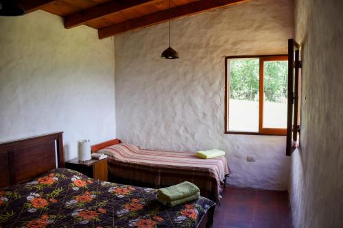 Habitación con 2 camas y ventana en Casa en Tafí del Valle en Tafí del Valle