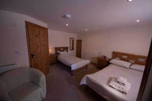 um quarto de hotel com duas camas e uma cadeira em Polhilsa Farm em Callington