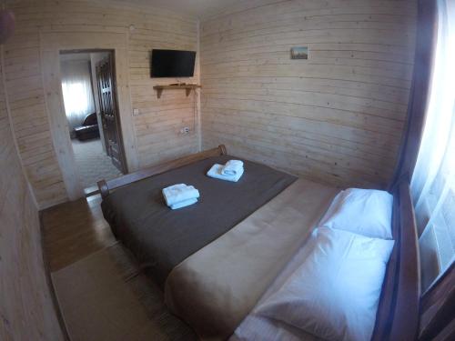 a bedroom with a bed with two towels on it at Айворі Хаус in Mykulychyn