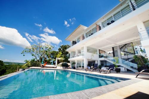 an exterior view of a house with a swimming pool at Ocean Suites Bohol Boutique Hotel in Tagbilaran City