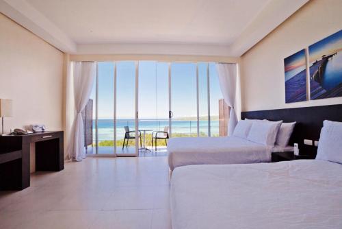 Postel nebo postele na pokoji v ubytování Ocean Suites Bohol Boutique Hotel