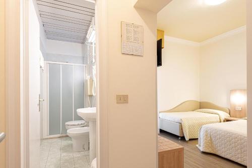 łazienka z toaletą, łóżkiem i umywalką w obiekcie Hotel Corinna w Rimini