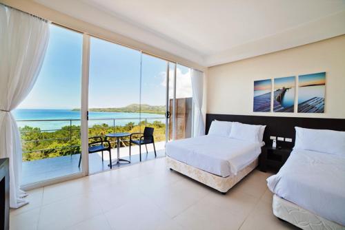 فندق أوشن سيوتس بوهول بوتيك في تاغبيلاران سيتي: غرفة نوم مع سرير وإطلالة على المحيط