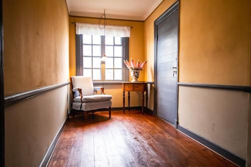 an empty hallway with a chair and a window at Hotell Dahlströmska gården in Vadstena