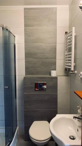 a bathroom with a toilet and a sink at Bianco - pokoje noclegowe in Częstochowa