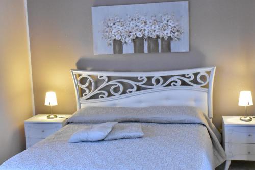 a bedroom with a white bed with two lamps at Bed and Breakfast Il Girasole in Mondello