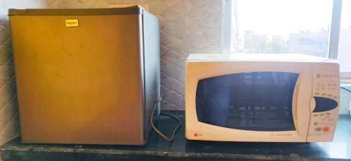 a microwave sitting on a counter next to a box at Cupidtrails Backpacker's Penthouse in Guwahati