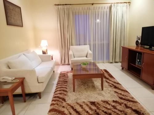 a living room with a couch and a coffee table at StayInn Gateway Hotel Apartment in Kuching