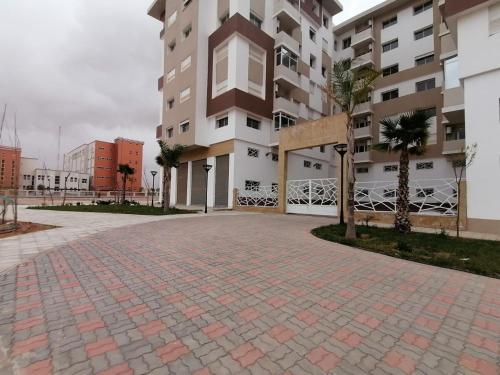 a large apartment building with a brick driveway at Haut Standing Appartement - Centre Ville Oujda in Oujda