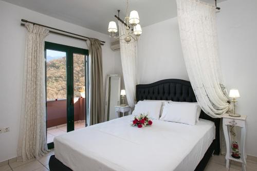 a bedroom with a white bed with flowers on it at Villa Mare e Monti in Almiros Beach