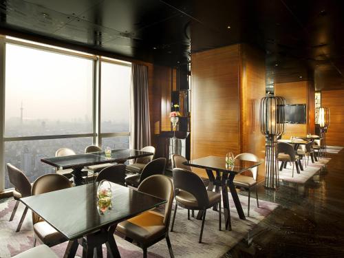 a restaurant with tables and chairs and a large window at Sofitel Nanjing Galaxy in Nanjing