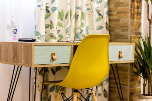 una silla amarilla sentada frente a un escritorio en Jolie maison Volos, en Volos