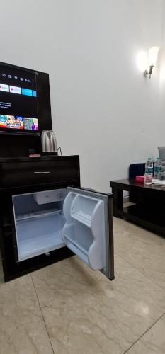 a small refrigerator with its door open in a living room at Nook Inn & Suites - MG ROAD METRO in Gurgaon