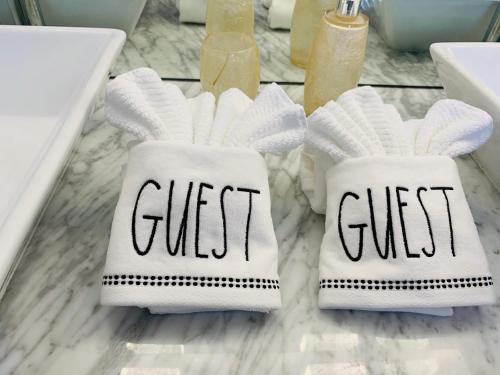 two towels with the word guest on them sitting on a bathroom counter at Sarasota Paradise Heated Pool Home Near IMG & Siesta Key Beach in Sarasota