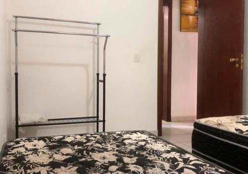 a bedroom with a bed with a black and white blanket at Casa Maresias Canto do mar - 50m da praia in Maresias