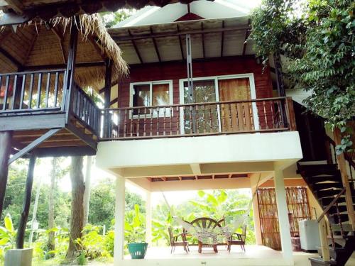 a house with a balcony and a table and chairs at Hallo Villa Khanom in Khanom