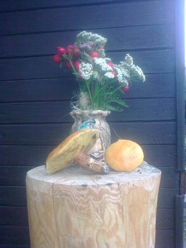 a table with a vase of flowers and vegetables on it at chata FRIDAY in Ktová