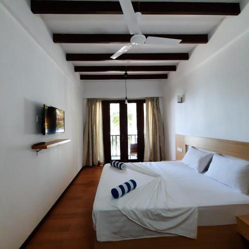 a bedroom with a white bed and a ceiling at Thundi Sea View in Fulidhoo