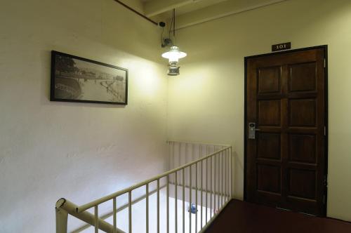a staircase with a wooden door and a picture on the wall at Red Inn Court in George Town