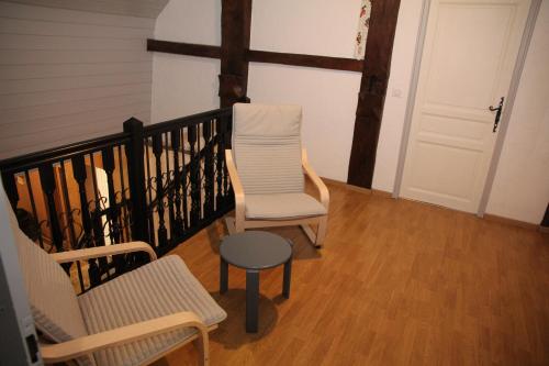 a balcony with two chairs and a table and a door at Gite Ferme Brelouffe 1 in La Rosière