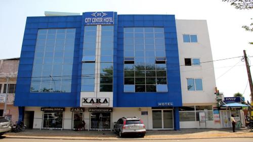 a blue and white building with a car parked in front at BENIN CITY CENTER HOTEL in Cotonou