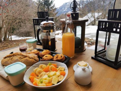 einen Tisch mit einem Teller mit Speisen und Orangensaft in der Unterkunft Les cabanes du domaine de l Esperluette in Le Lauzet-Ubaye