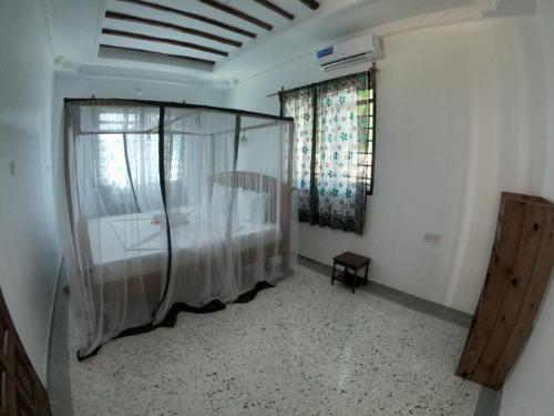 a bedroom with a bed and a window in a room at kome-Maya garden in Jambiani