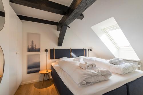 a bedroom with a large bed with towels on it at City Center Penthouse in Sønderborg