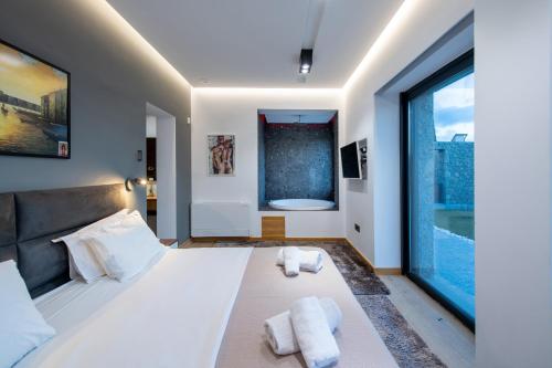 a bedroom with a large bed and a large window at Villa BLUELINE in Alykes Potamou