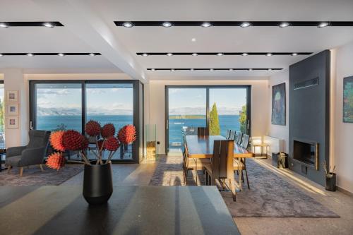 a dining room with a table and chairs and a view of the ocean at Villa BLUELINE in Alykes Potamou