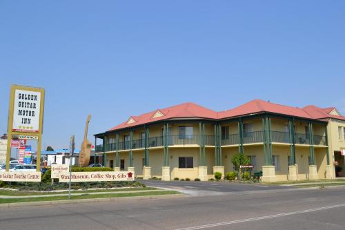 a building with a red roof on the side of a street at Golden Guitar Motor Inn in Tamworth