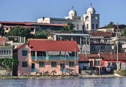 un edificio con techo rojo junto al agua en Hostal Don Cenobio, en Flores