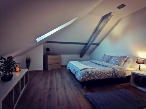a bedroom with a bed and a dresser in a attic at Cosy chic in Erstein