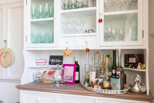 a cabinet filled with lots of bottles and glasses at Pension Tadtendrang in Tadten